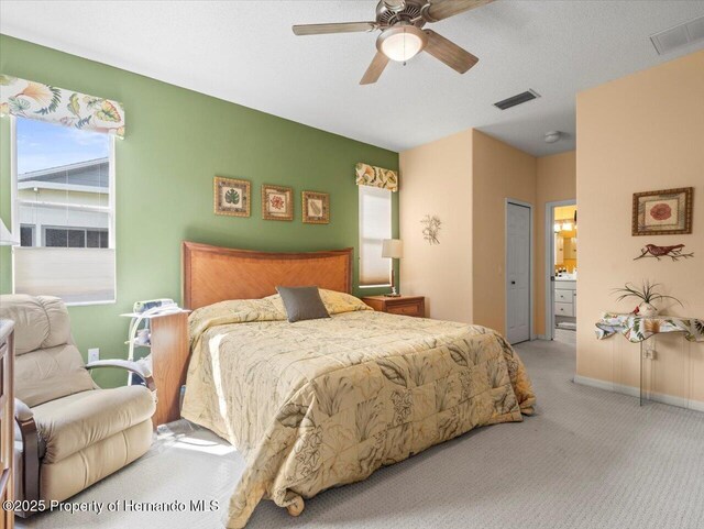 18514 Hidden Pines Way, Hudson, FL 34667 - bedroom featuring carpet flooring, connected bathroom, a ceiling fan, baseboards, and a closet
