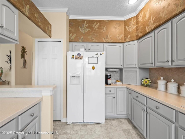 18514 Hidden Pines Way, Hudson, FL 34667 - kitchen featuring white refrigerator with ice dispenser, gray cabinetry, tasteful backsplash, light countertops, and ornamental molding