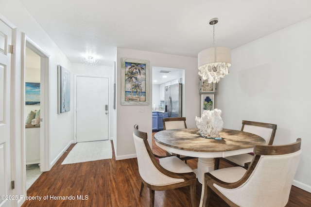 4008 Passport Ln, New Port Richey, FL 34653 - dining room featuring a chandelier, dark wood-type flooring, and baseboards