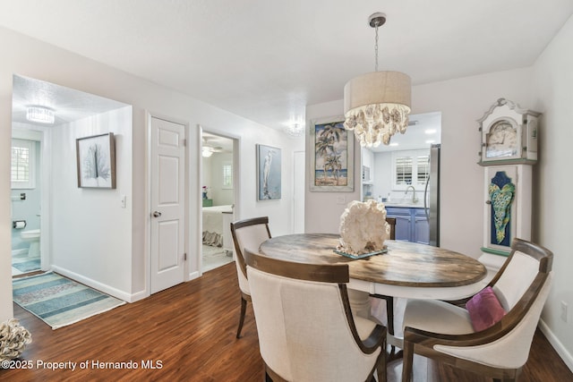 4008 Passport Ln, New Port Richey, FL 34653 - dining area featuring dark wood finished floors, baseboards, and a chandelier
