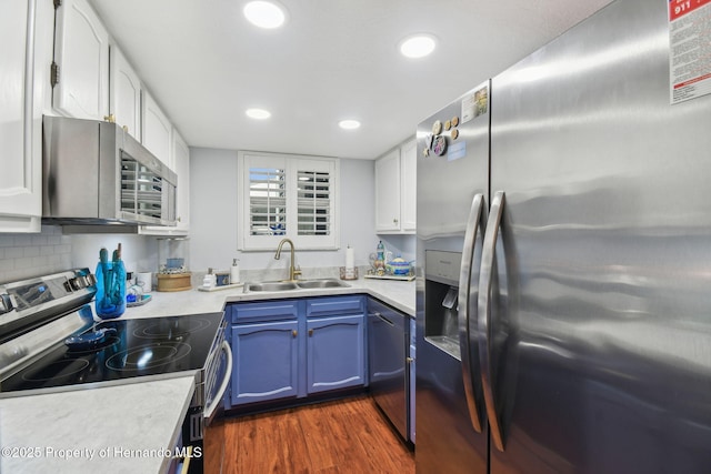 4008 Passport Ln, New Port Richey, FL 34653 - kitchen featuring stainless steel appliances, a sink, blue cabinets, white cabinets, and light countertops