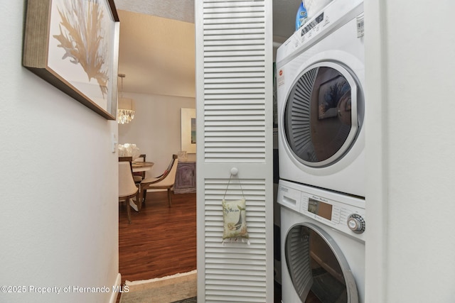 4008 Passport Ln, New Port Richey, FL 34653 - washroom with stacked washer and clothes dryer, wood finished floors, a chandelier, and baseboards