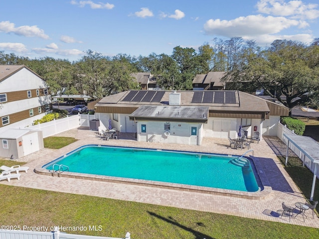 4008 Passport Ln, New Port Richey, FL 34653 - community pool featuring a patio, a fenced backyard, and view of wooded area