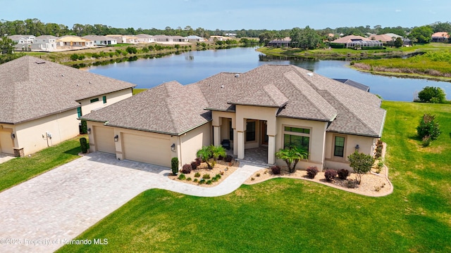 view of front of house featuring a garage, a water view, and stucco siding
