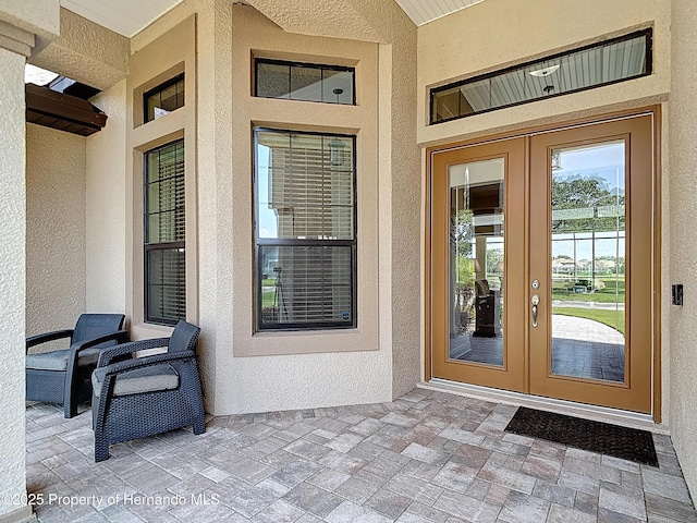 entrance to property featuring french doors and stucco siding
