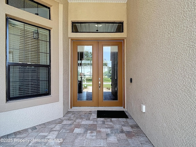 entrance to property with french doors and stucco siding