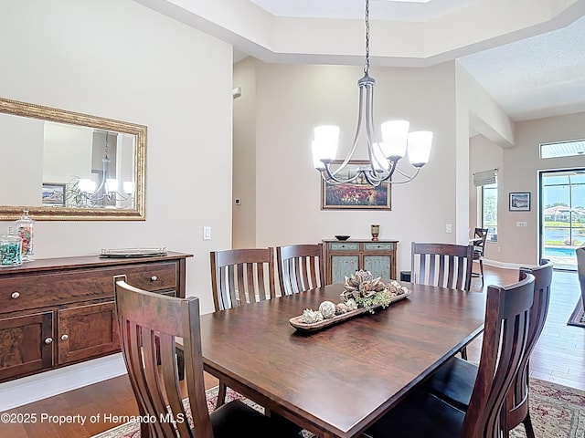 dining space with dark wood-style floors and a chandelier