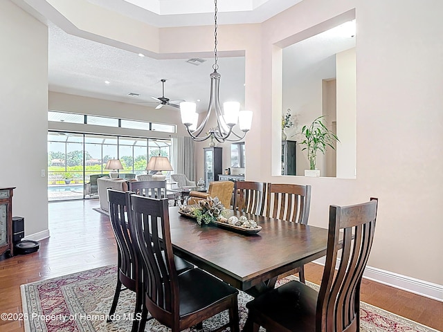 dining area with wood finished floors, a chandelier, and baseboards
