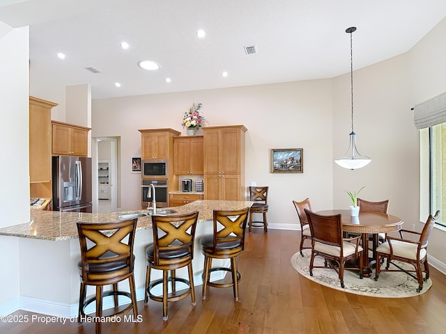 kitchen with appliances with stainless steel finishes, baseboards, a sink, dark wood finished floors, and recessed lighting