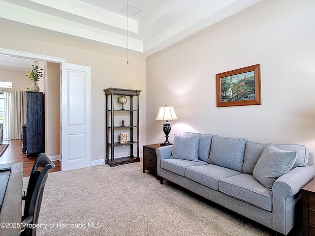 carpeted living area with baseboards
