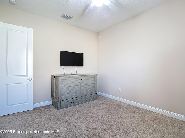 unfurnished bedroom with carpet floors, baseboards, a textured ceiling, and ceiling fan