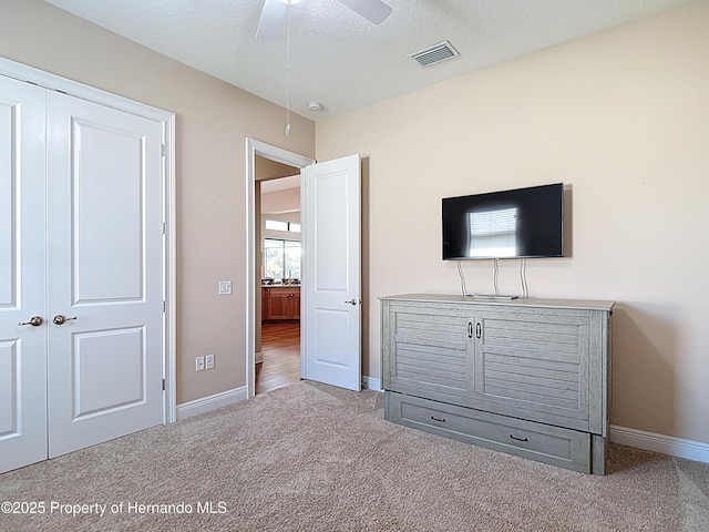 unfurnished bedroom with carpet, baseboards, a closet, and a ceiling fan