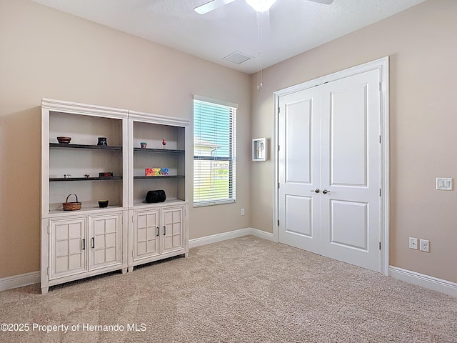 unfurnished bedroom featuring light colored carpet, baseboards, and a closet