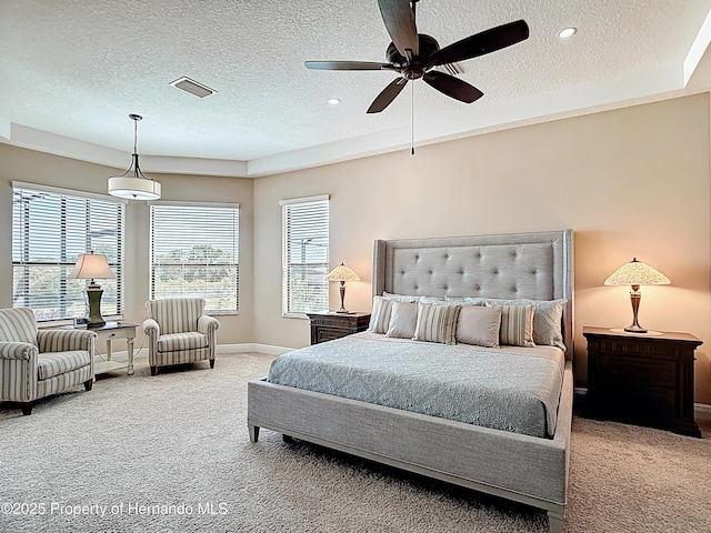 carpeted bedroom with a textured ceiling, baseboards, and ceiling fan