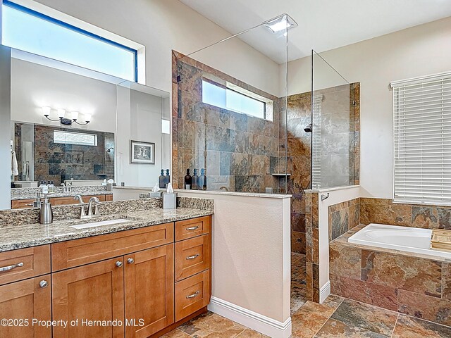 full bathroom featuring walk in shower, vanity, a garden tub, and stone finish flooring