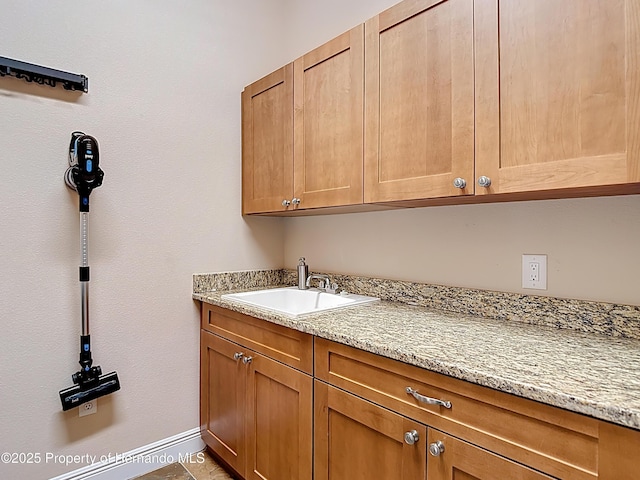washroom featuring a sink and baseboards