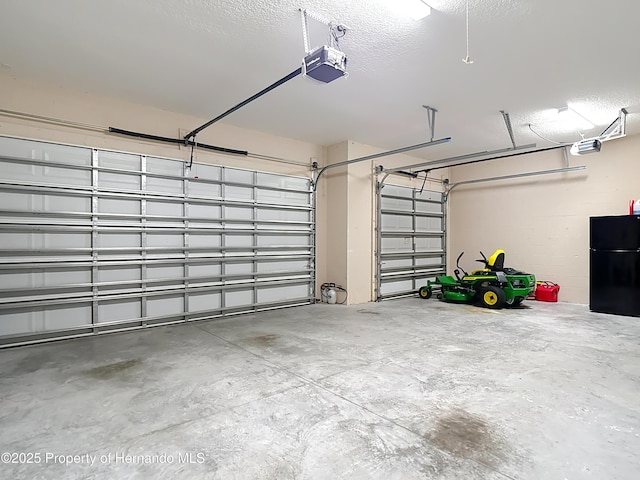 garage with freestanding refrigerator and a garage door opener