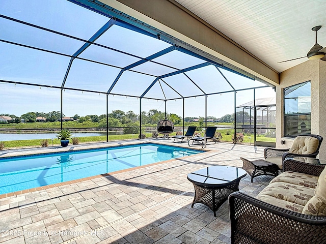 swimming pool with a patio area, ceiling fan, a lanai, a water view, and an outdoor living space