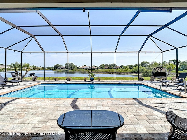 swimming pool with a patio area, a water view, and a lanai