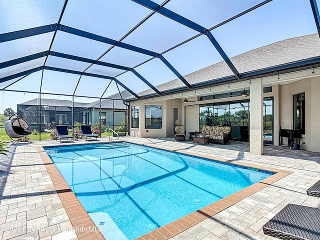 outdoor pool with a ceiling fan, an outdoor hangout area, a patio area, and a lanai