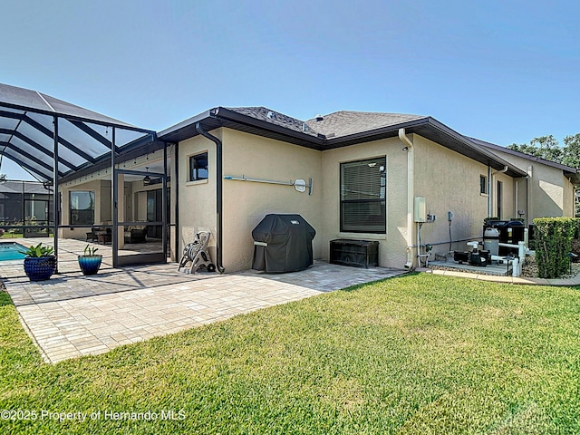 back of property with stucco siding, a patio area, a lawn, an outdoor pool, and a lanai