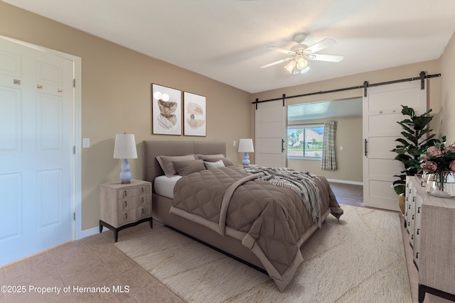 4446 San Juan Dr, Hernando Beach, FL 34607 - bedroom with a barn door, light tile patterned floors, baseboards, and a ceiling fan