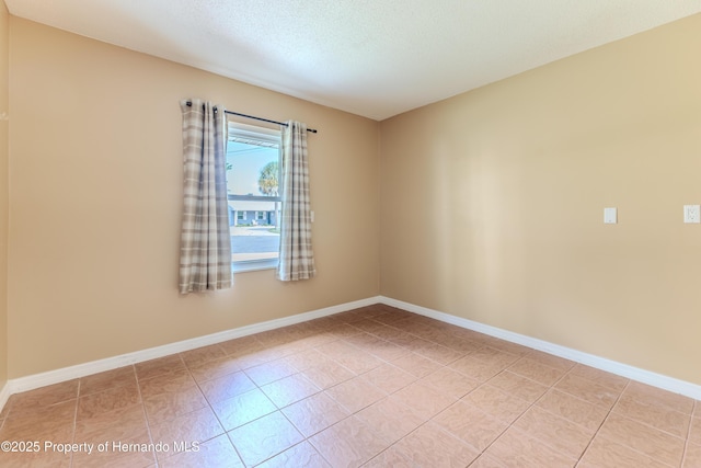 4446 San Juan Dr, Hernando Beach, FL 34607 - empty room featuring light tile patterned floors, baseboards, and a textured ceiling