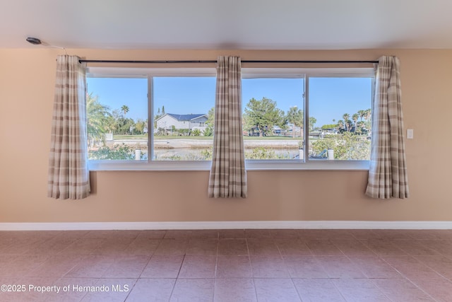 4446 San Juan Dr, Hernando Beach, FL 34607 - tiled empty room featuring baseboards