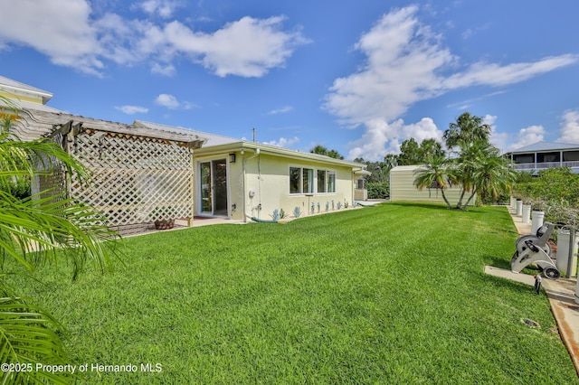 4446 San Juan Dr, Hernando Beach, FL 34607 - back of property featuring stucco siding and a lawn
