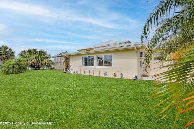 4446 San Juan Dr, Hernando Beach, FL 34607 - view of side of home with stucco siding and a lawn
