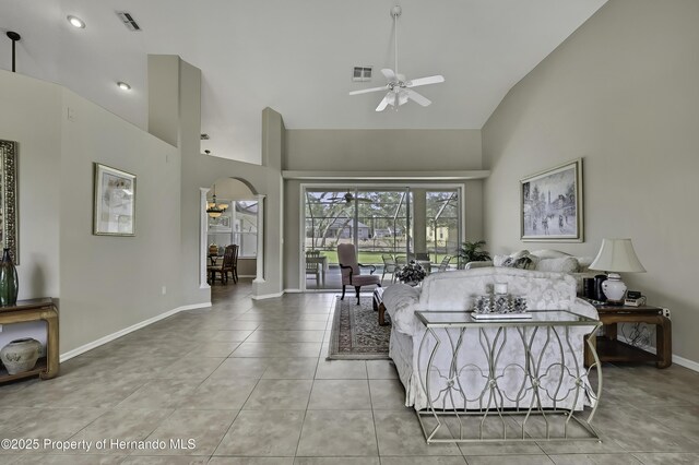 11336 Flower Ave, Weeki Wachee, FL 34613 - living room featuring high vaulted ceiling, visible vents, ceiling fan, light tile patterned floors, and baseboards