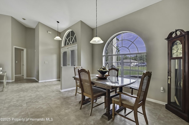 11336 Flower Ave, Weeki Wachee, FL 34613 - tiled dining area featuring baseboards and high vaulted ceiling