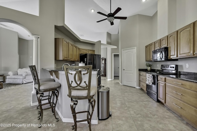 11336 Flower Ave, Weeki Wachee, FL 34613 - kitchen featuring a kitchen bar, a ceiling fan, high vaulted ceiling, electric range oven, and black microwave