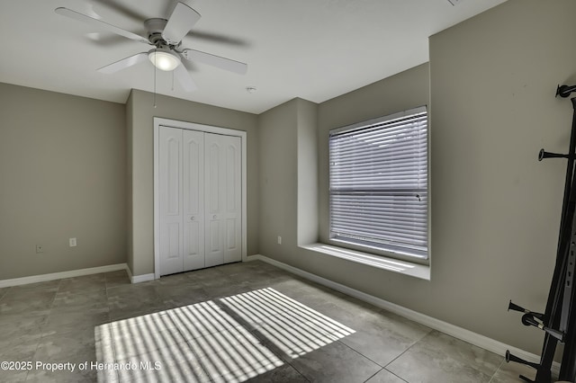 11336 Flower Ave, Weeki Wachee, FL 34613 - unfurnished bedroom with ceiling fan, baseboards, and a closet
