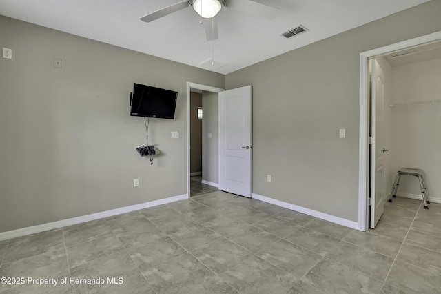11336 Flower Ave, Weeki Wachee, FL 34613 - unfurnished bedroom with a closet, visible vents, ceiling fan, a spacious closet, and baseboards