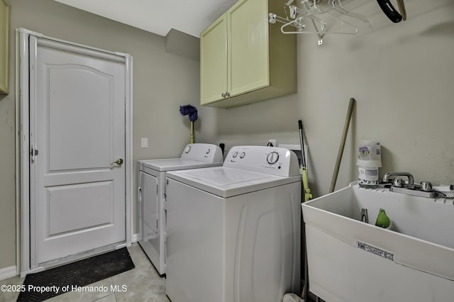 11336 Flower Ave, Weeki Wachee, FL 34613 - clothes washing area with a sink, cabinet space, light tile patterned floors, and washer and dryer