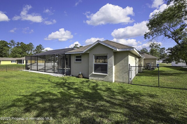 11336 Flower Ave, Weeki Wachee, FL 34613 - rear view of property featuring a lawn, stucco siding, a fenced backyard, and a lanai