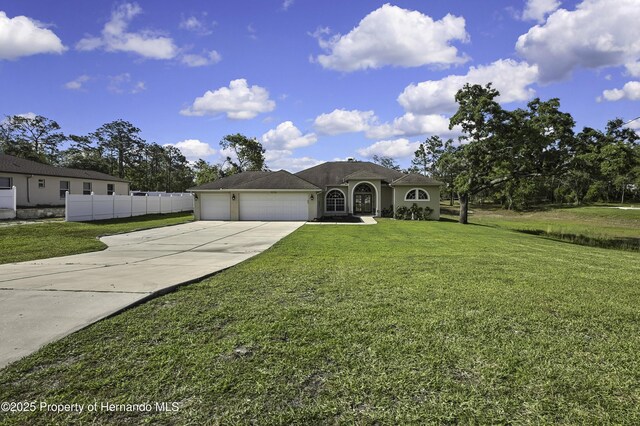 11336 Flower Ave, Weeki Wachee, FL 34613 - single story home with a front yard, an attached garage, fence, and driveway