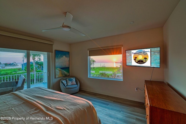 bedroom with access to outside, wood finished floors, baseboards, and a ceiling fan