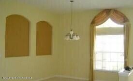 4301 Blakemore, Spring Hill, FL 34609 - unfurnished dining area featuring arched walkways and baseboards