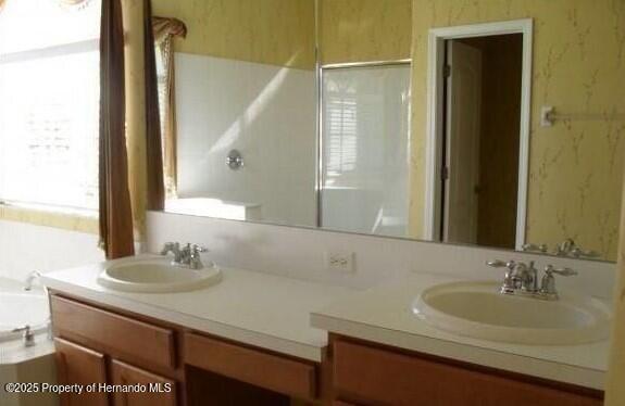 4301 Blakemore, Spring Hill, FL 34609 - bathroom featuring wallpapered walls, double vanity, a garden tub, and a shower
