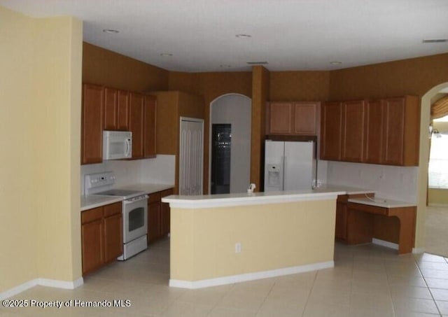 4301 Blakemore, Spring Hill, FL 34609 - kitchen featuring white appliances, arched walkways, a center island, light countertops, and light tile patterned floors