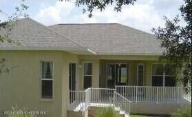 4301 Blakemore, Spring Hill, FL 34609 - back of property featuring a shingled roof, a porch, and stucco siding