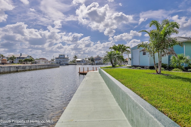 dock featuring a water view, a yard, and a residential view