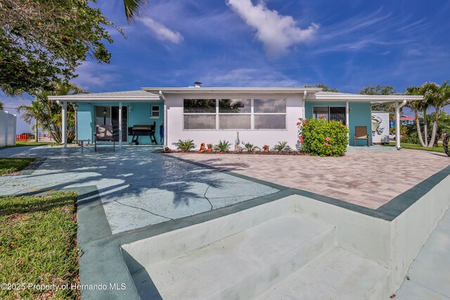 back of property featuring stucco siding