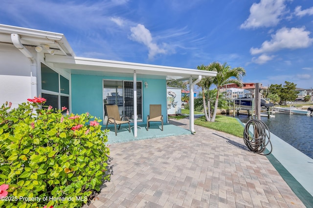 view of patio featuring a water view and a boat dock