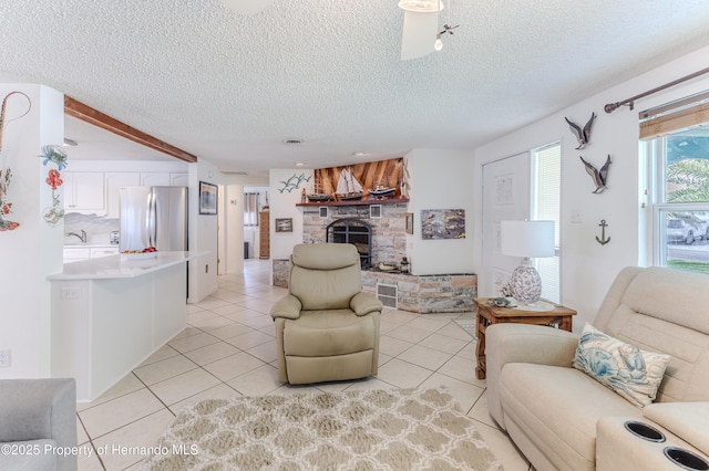 living room with a fireplace, light tile patterned flooring, and a textured ceiling