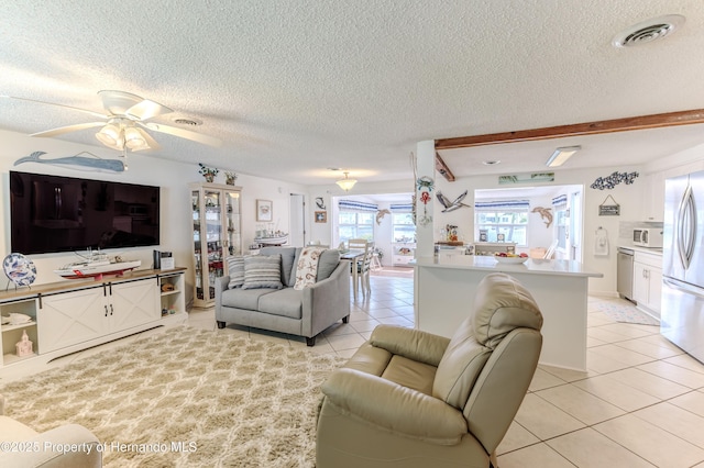 living area featuring light tile patterned floors, a textured ceiling, and a ceiling fan