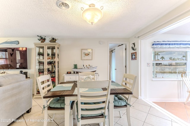 dining room with light tile patterned flooring and a textured ceiling