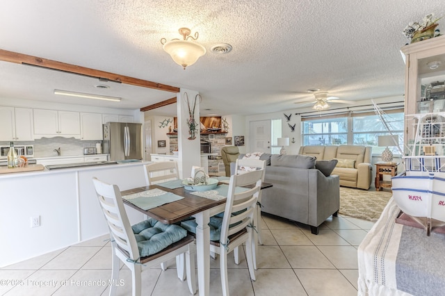 dining room featuring light tile patterned floors, ceiling fan, and a textured ceiling